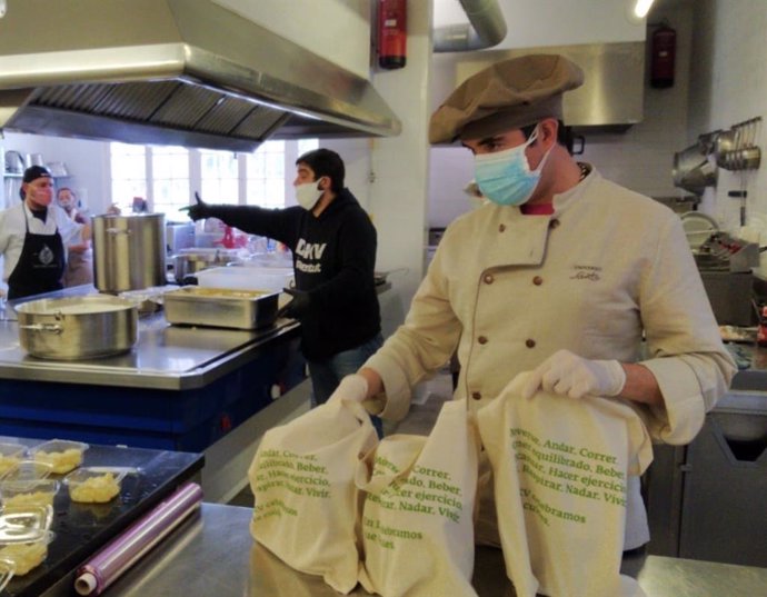 Voluntarios del proyecto Cocina Solidaria, como de La Lanzada, gestionan lo menús de Universo Santi para repartirlos por la ciudad.