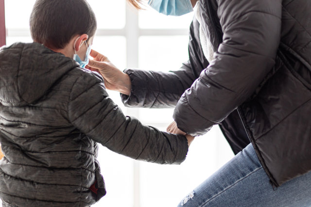 Una madre coloca a su hijo una mascarilla un día después de que Pedro Sánchez, haya confirmado que los niños podrán salir a la calle "con condiciones" a partir del 27 de abril