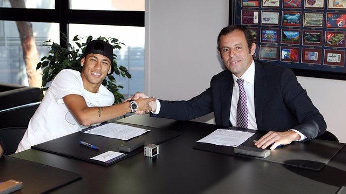 El jugador Neymar amb Sandro Rosell signant el contracte