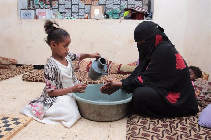 Mujer y niña lavándose las manos en Yemen