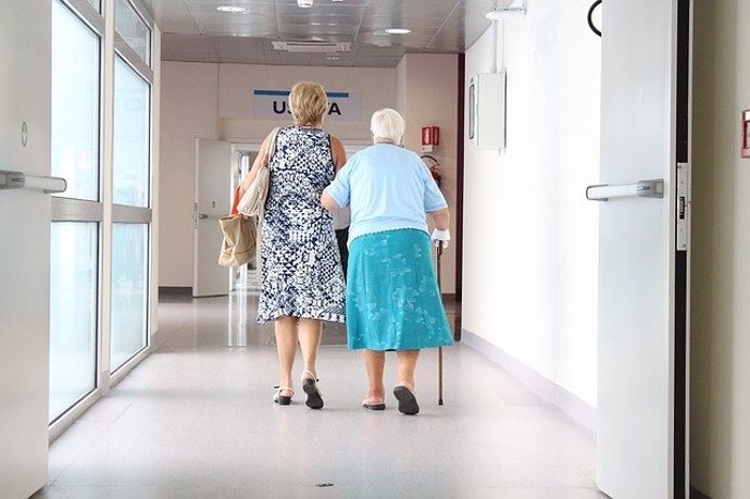 Anciana acompañada de su hija a la salida del hospital.