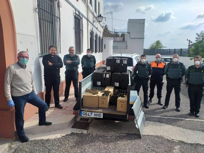 Agentes de la Guardia Civil, representantes de Cáritas y el párroco de Aguilar.