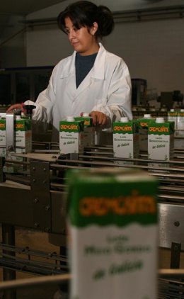 Trabajadora en una fábrica de envases de leche.