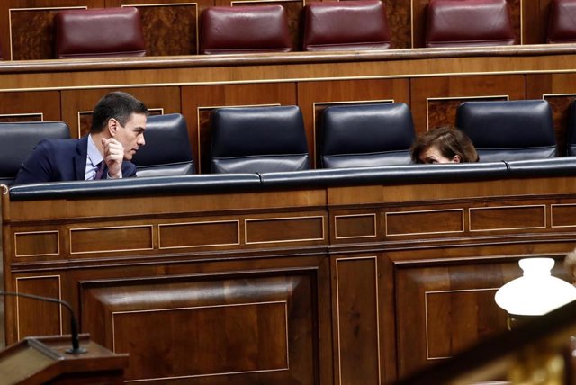 La vicepresidenta del Gobierno, Carmen Calvo (d) conversa con el presidente, Pedro Sánchez (i) durante el pleno extraordinario para explicar la declaración del estado de alarma en Madrid (España), a 18 de marzo de 2020.