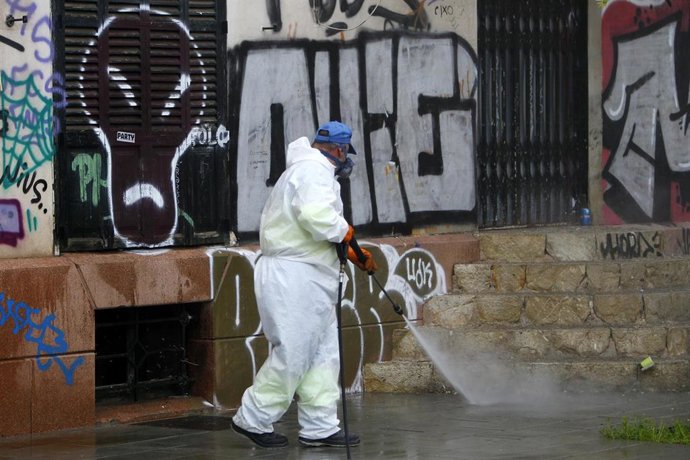 Un trabajador de limpieza desinfecta escaleras cercanas a la estación Intermodal el primer día en el que las fuerzas de Seguridad del Estado están repartiendolas con motivo de la reactivación de la actividad laboral no esencial en Palma 