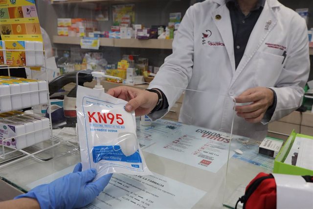 Un farmacéutico vende una mascarilla en su farmacia durante el segundo mes de confinamiento, en Madrid (España) a 20 de abril de 2020.