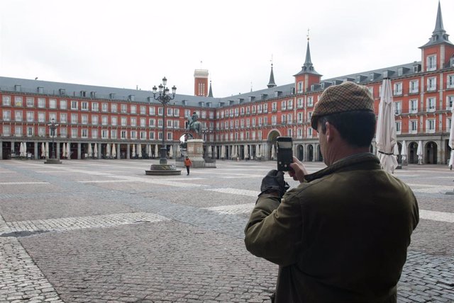 Un hombre hace una foto con su móvil a la céntrica Plaza Mayor de Madrid