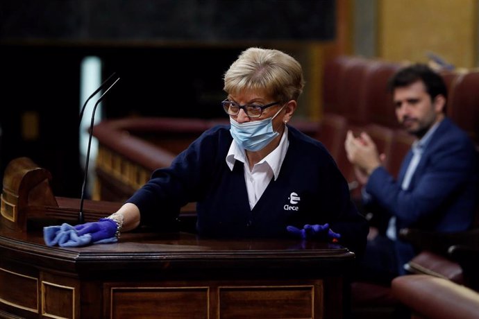 Conchi García, trabajadora del servicio de limpieza del Congreso, desinfecta la tribuna de oradores del hemiciclo.