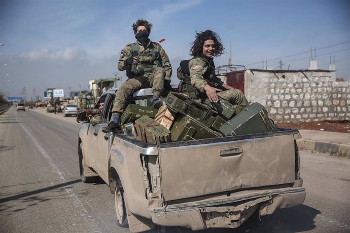 Combatientes del Frente Nacional para la Liberación, una facción de la oposición armada siria, patrullan en las calles de Saraqib, noroeste de Siria.