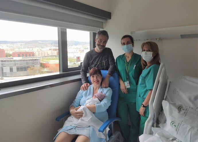 Una familia con su recién nacido en brazos junto a sanitarios