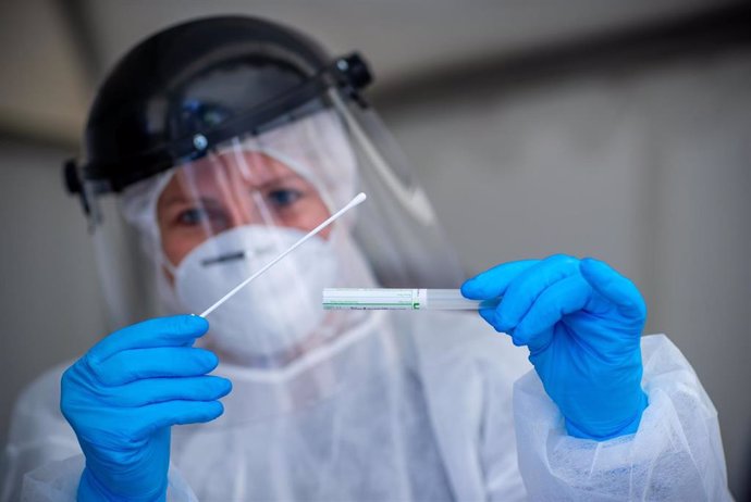 17 April 2020, Mecklenburg-Western Pomerania, Buetzow: A medic holds a takes a smear sample after collecting it from a person inside a car at a testing center for possible coronavirus cases. Photo: Jens Büttner/dpa-Zentralbild/dpa