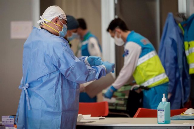 Un sanitario se prepara antes de iniciar su jornada laboral en el Pabellón 9 del hospital de campaña de IFEMA.