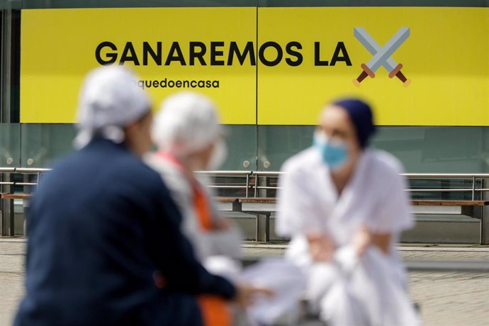 Sanitarios junto a un cartel en el que se lee 'Ganaremos la batalla' en el hospital de campaña de IFEMA, en el que los pacientes de coronavirus son ahora atendidos únicamente en el Pabellón 9 tras el cierre del 7 al bajar la presión asistencial y que es