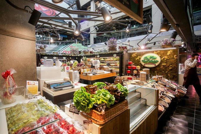 Puesto de verduras y hortalizas en el mercado de San Antón, que permanece abierto en plena crisis del coronavirus y anuncia que también atiende a domicilio, en Madrid (España), a 18 de marzo de 2020.