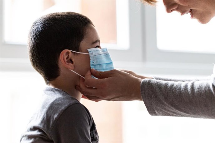 Una mare colloca el seu fill una mascarilla durant el confinament pel coronavirus. 