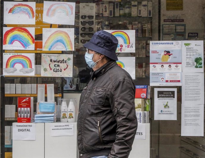 Un hombre con mascarilla pasa junto a una farmacia con dibujos infantiles en su escaparate durante el reparto de mascarillas gratuitas contra el Covid-19 a mayores de 65 años y colectivos de riesgo que ayer arrancó en la Comunitat Valenciana. Después de