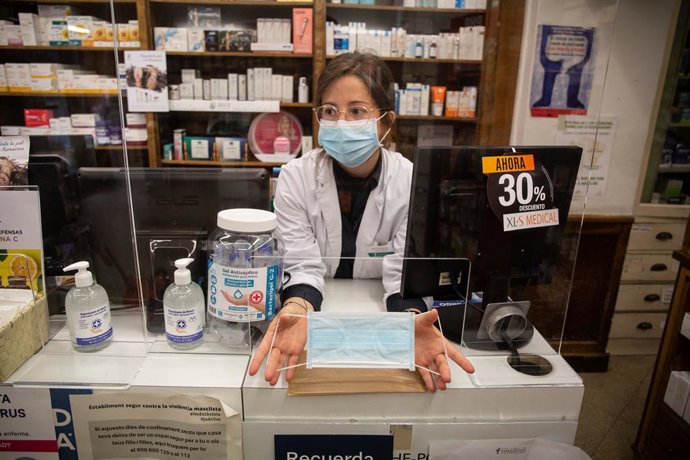 Una farmacutica mostra una de les mascarillas que la Generalitat ha comenat avui a repartir a la població dins d'una primera tanda d'1,5 milions d'unitats.