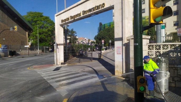 Operario de Limasa en labores de desinfección en la puerta del Hospital Regional de Málaga