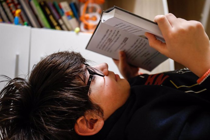 Un niño lee en su cuarto cuando queda tan solo una semana para que niños y preadolescentes puedan salir a la calle durante el confinamiento por el coronavirus, en Valdemoro/Madrid (España) a 20 de abril de 2020.