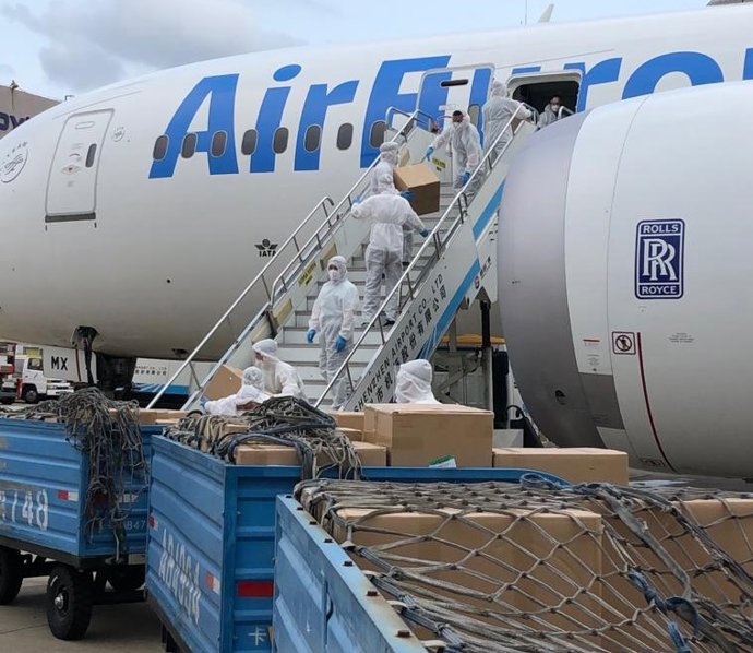 Operarios descargan las cajas con mascarillas de protección