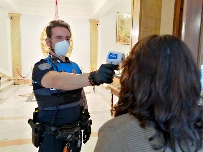 Un agente municipal tomando la temperatura.