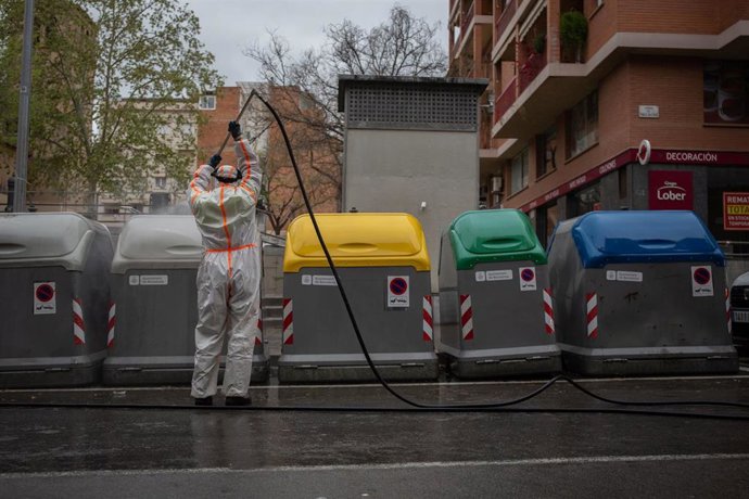 Un trabajador desinfecta y limpia los contenedores de basura de Barcelona durante la tercera semana de confinamiento por la crisis del coronavirus
