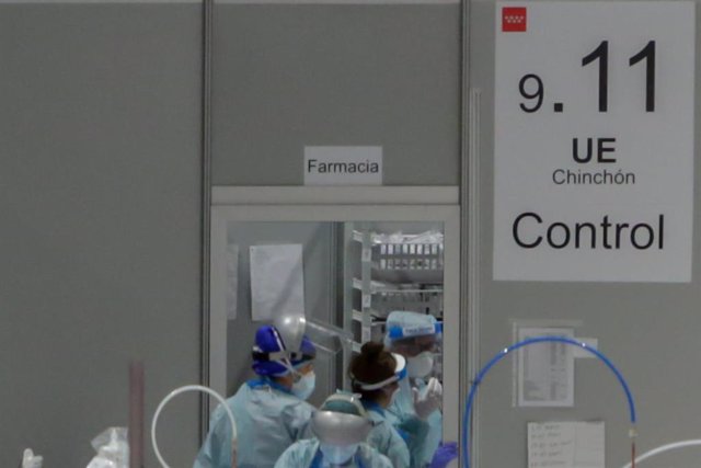 Sanitarios protegidos con mascarillas, gorros y pantallas protectoras en la puerta del almacén de material farmacéutico en el Hospital temporal de la Comunidad de Madrid habilitado en IFEMA para pacientes con coronavirus, en Madrid  a 31 de marzo de 2020.