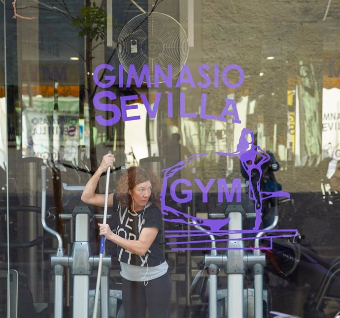 Una limpiadora refuerza la desinfección de un gimnasio para combatir la propagación del coronavirus en Sevilla