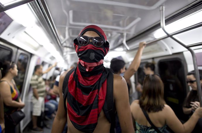 Un hombre se cubre la cara con sus ropas mientras viaja en el metro de Río de Janeiro.
