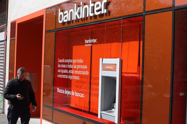 Un hombre pasa al lado de un cajero del banco Bankinter en una de sus oficinas de la capital