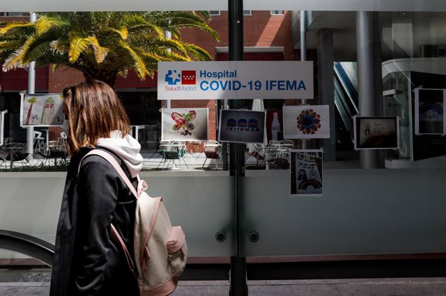 Una mujer pasa junto a unos dibujos infantiles en el hospital de campaña de Ifema
