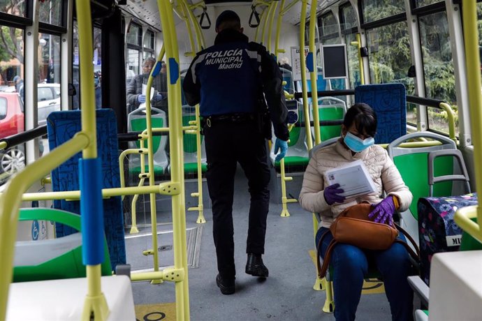 Un policía municipal de Madrid realiza un control a los pasajeros de un autobús 