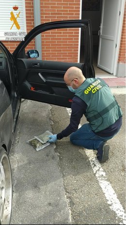 Un agente de la Guardia Civil localiza las dos bolsas con la droga en el coche de los dos detenidos.