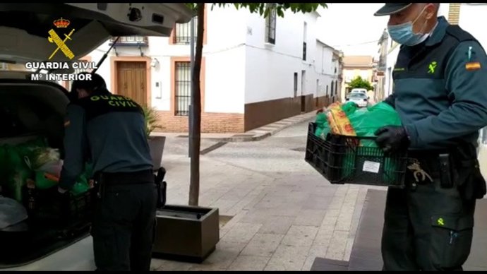 Una patrulla de la Guardia Civil entrega alimentos