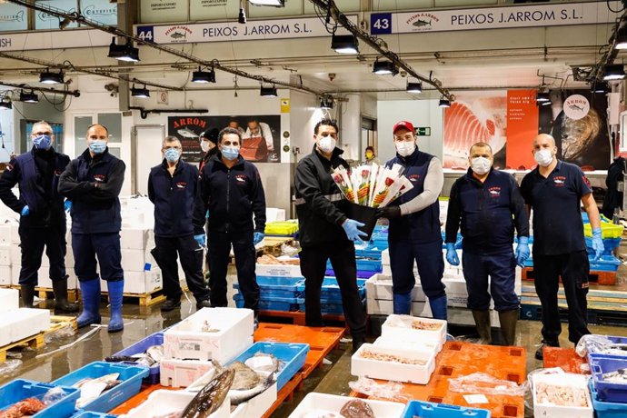 Trabajadores en Mercabarna este jueves con algunas de las rosas que ha repartido el recinto alimentario