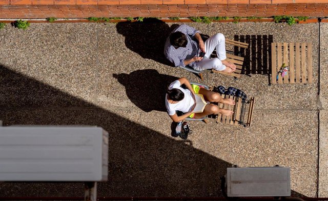 El patio interior de una vivienda es  utilizados por estos vecinos para tomar el sol y leer. Sevilla a 29 de marzo del 2020