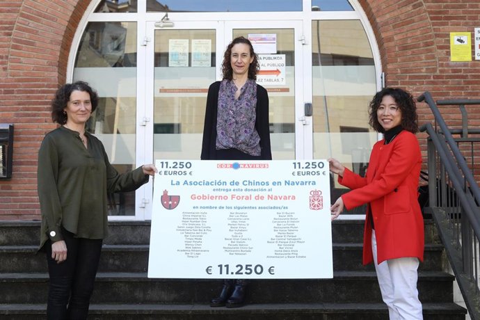 Mónica Yu entrega el cheque a las representantes del Gobierno de Navarra.