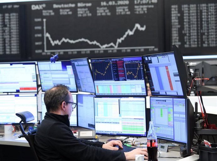 16 March 2020, Frankfurt/Main: A estoc trader sits in front of his monitors in the trading room of the Frankfurt Estoc Exchange. As a result of the worsening coronavirus crisi, the German share index Dax has fallin below the 9000 point mark. Photo: Arne 