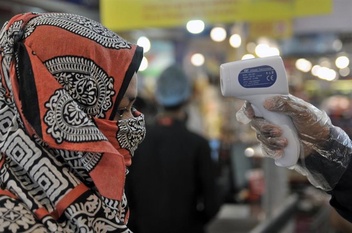 Una mujer es sometida a un examen de temperatura por el Covid-19.