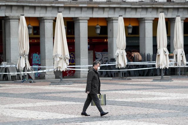 Un hombre con mascarilla anda por la Plaza Mayor 