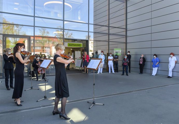 Músicos del teatro estatal de Cottbus dan un concierto en la entrada de un hospital