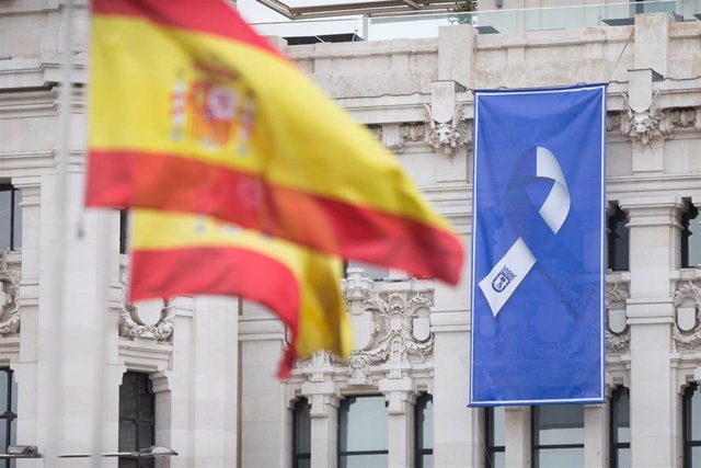 Bandera de España en la Fuente de Cibeles y bandera con el lazo que simboliza la lucha unida del pueblo de Madrid 