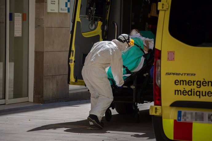 Un sanitario protegido con un traje sube a una persona contagiada con coronavirus a una ambulancia en el Centro de Emergencias de Atención Primaria Pere Camps en el Raval (España) a 6 de abril de 2020. (archivo)