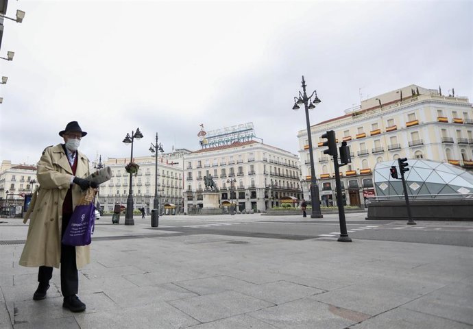 Un hombre camina protegido con mascarilla por la Puerta del Sol de la capital