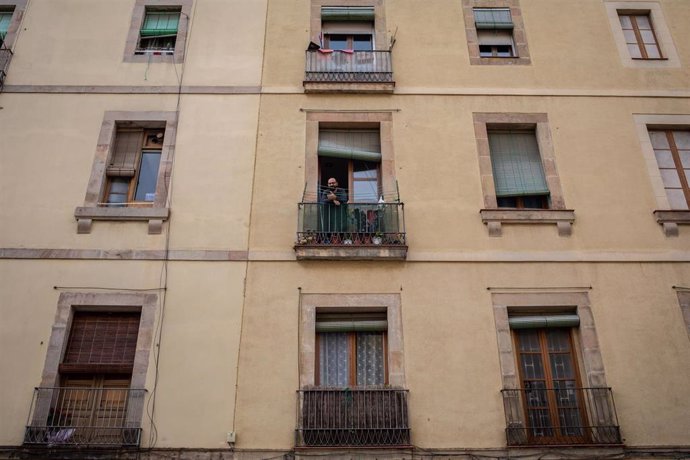 Un hombre se asoma al balcón durante el tercer día laborable del estado de alarma por coronavirus, en Barcelona/Catalunya (España) a 18 de marzo de 2020.