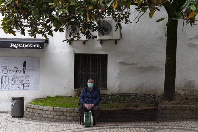Un hombre protegido con mascarilla sentado en un banco en A Coruña en el día 41 del estado de alarma por la crisis sanitaria del Covid-19 .