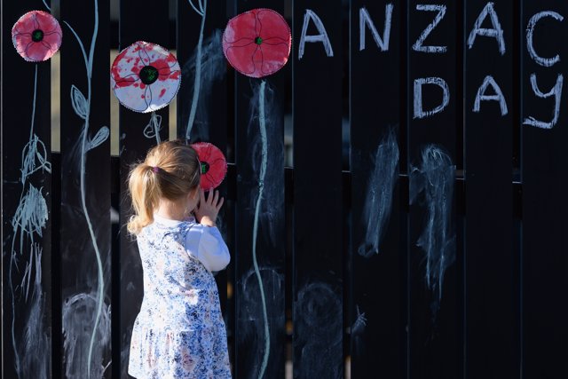  Louise Boivin, de tres años, coloca una amapola en la cerca de la casa de su familia el 25 de abril de 2020 en Christchurch, Nueva Zelanda.