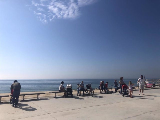 Familias pasean cerca de una playa de Barcelona en el primer día en que se permite salir con niños a la calle desde la declaración del estado de alarma por el coronavirus.