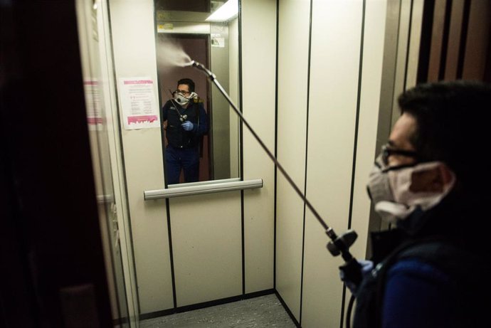 Un operario de la Empresa Montesa SL desinfecta el interior de un ascensor que forma parte de las zonas comunitarias de una comunidad de vecinos en el barrio de Salamanca, en Madrid (España) a 20 de abril de 2020.