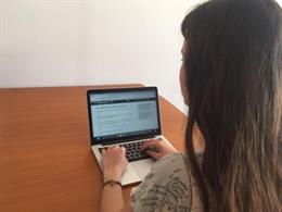 Una alumna estudia con un ordenador.
